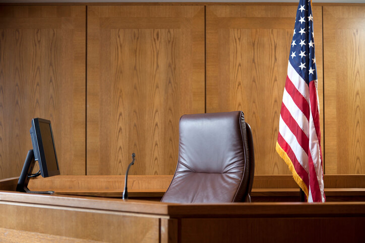 Courtroom bench in a wood paneled courtroom.