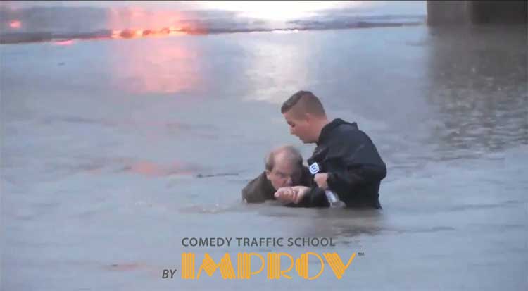 Two men standing up in flood waters holding a television microphone.