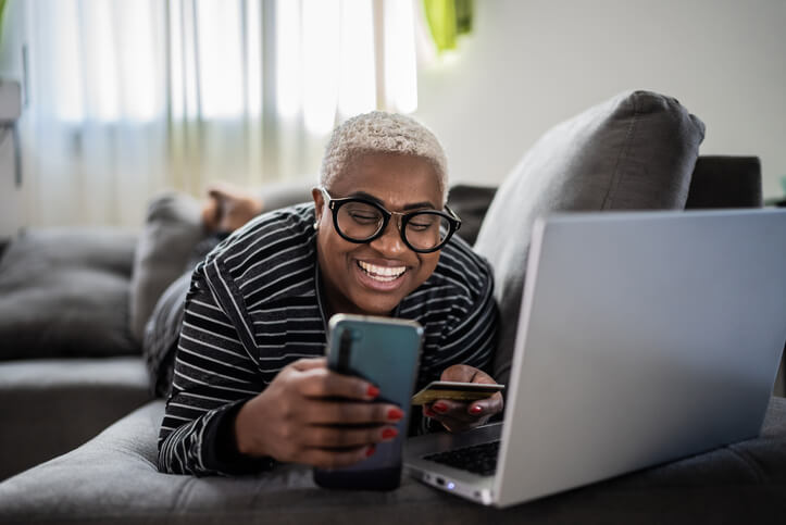 A person with their phone and laptop having a good time attending online traffic school.